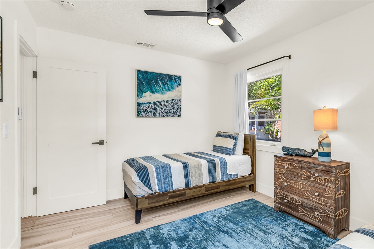 Bedroom 4 features cozy twin beds with nautical-inspired decor and soft coastal tones, perfect for kids, friends, or guests seeking a bright and cheerful space to unwind.