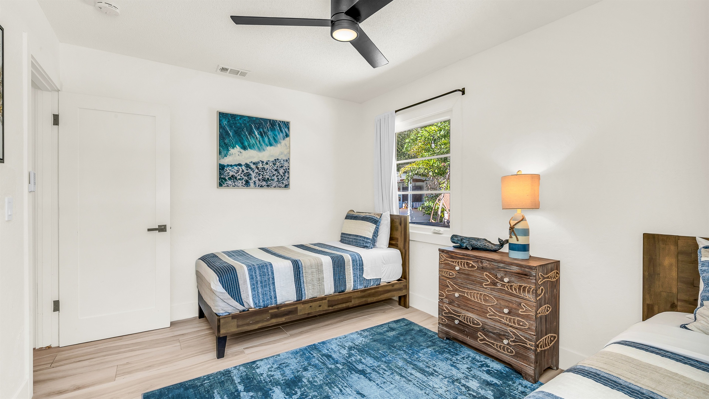 Bedroom 4 features cozy twin beds with nautical-inspired decor and soft coastal tones, perfect for kids, friends, or guests seeking a bright and cheerful space to unwind.