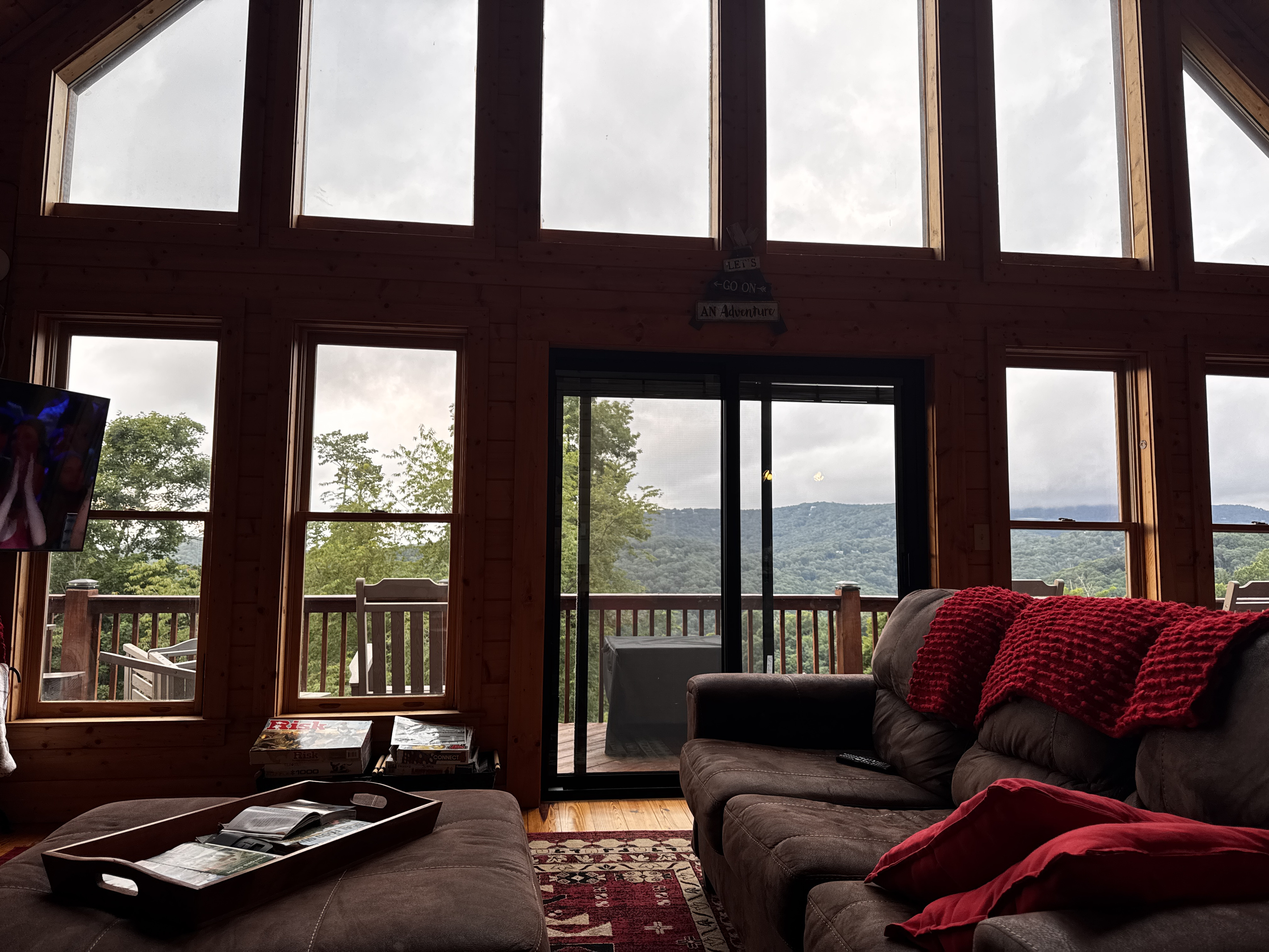 Relax in the living room with mountain views visible through the cabin's expansive windows.