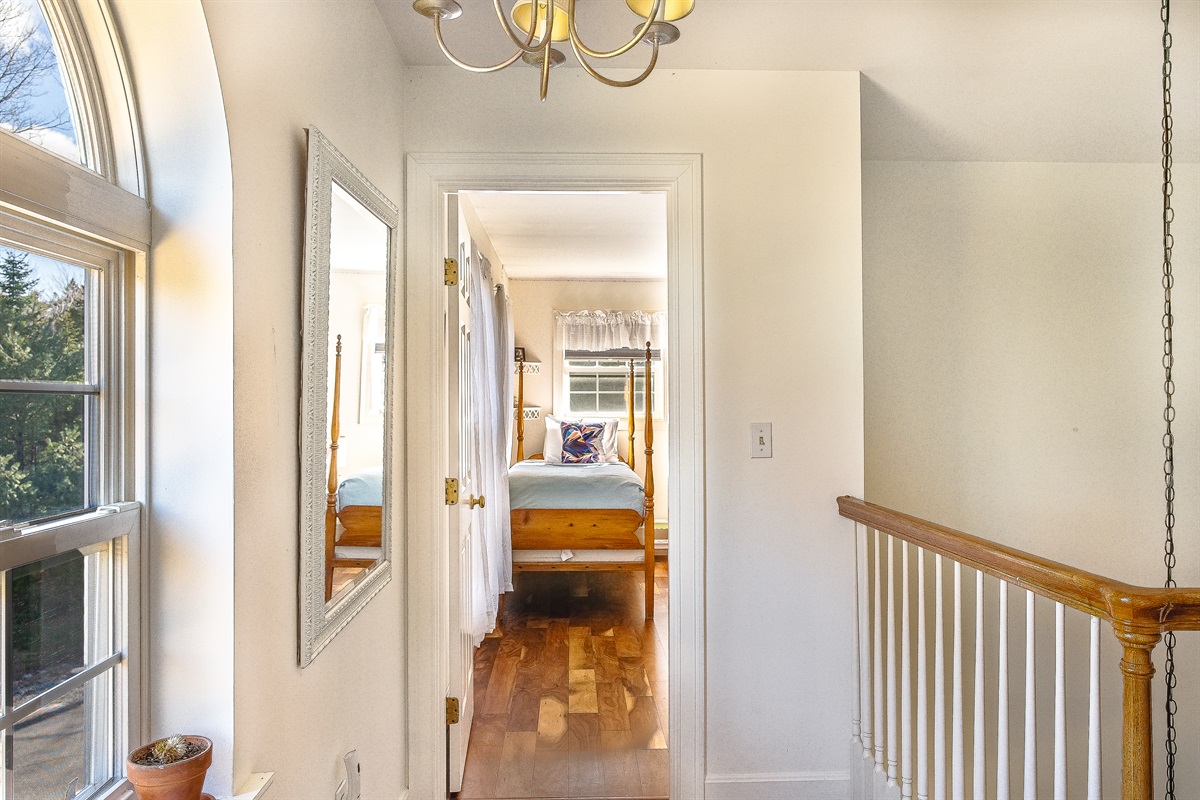 Step into the bright and inviting twin guest room, located just off the sunlit second-floor landing. This versatile space features beautiful hardwood floors and charming four-poster beds, perfect for children or additional guests at Seven Peaks Ridge.