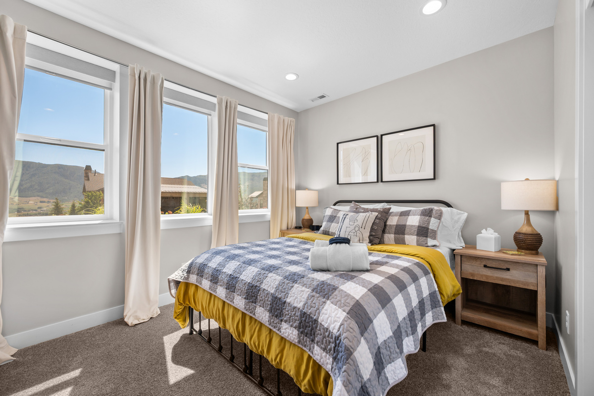 Comfortable upper-level bedroom featuring a king bed, soft linens, and a peaceful space to relax after a day of mountain adventures.