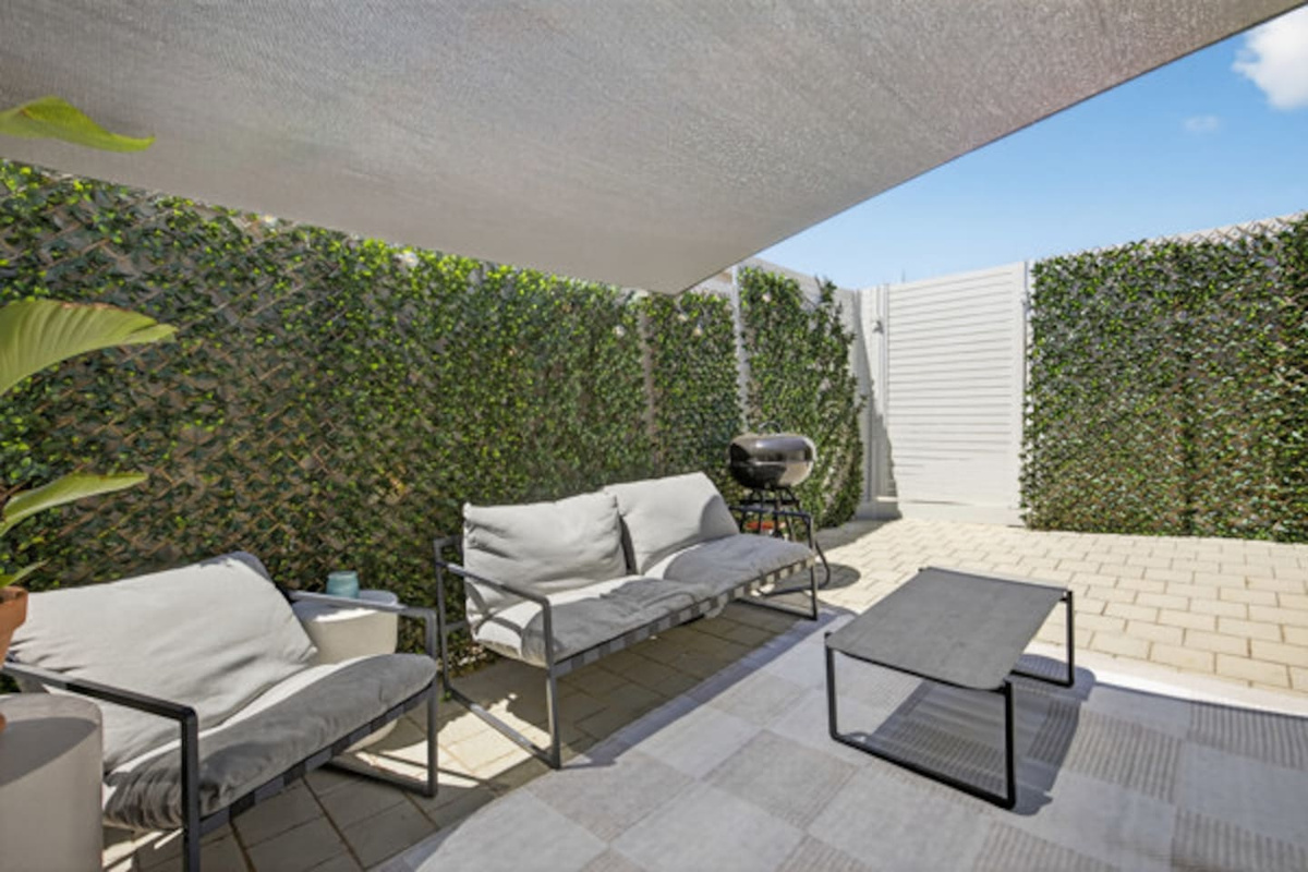 Relax in the private, leafy courtyard with comfy outdoor sofas under a shade sail and a kettle barbecue for easy evening meals.