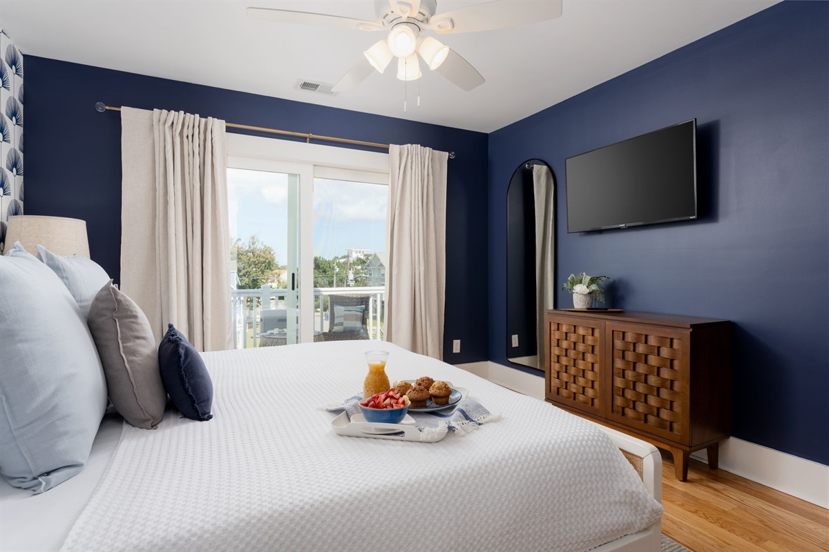 Comfortable king bed with wall-mounted TV — perfect for winding down after a beach day.