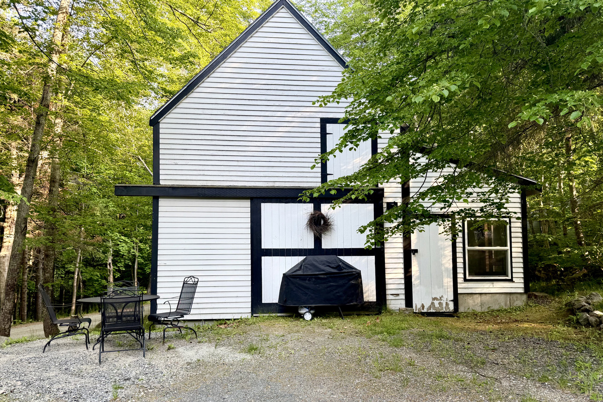 Fire up the propane grill for an open-air dinner behind the historic barn. This peaceful outdoor dining area features seating for four, providing the perfect setting for a relaxed backyard barbecue surrounded by the Maine woods.