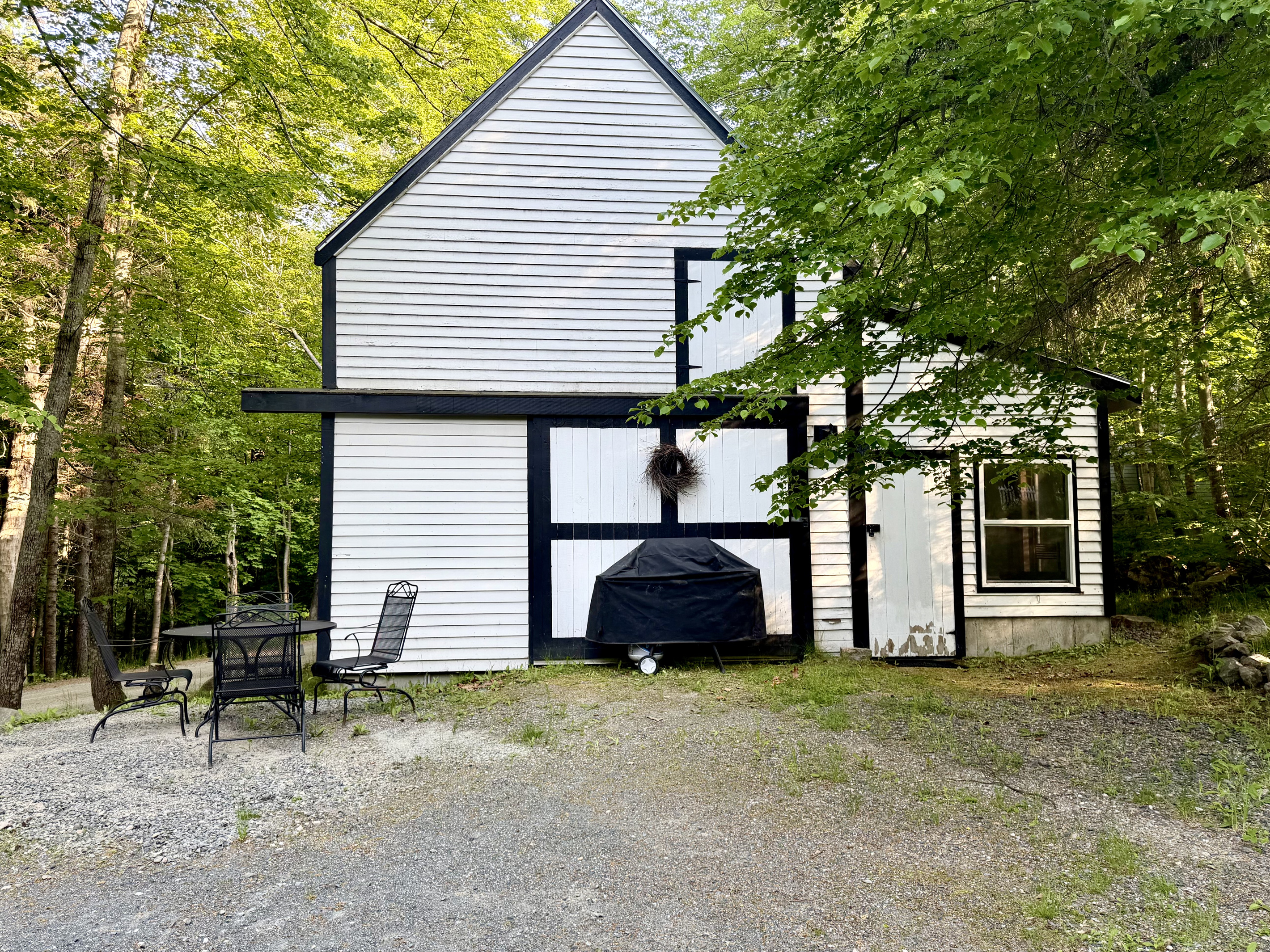 Fire up the propane grill for an open-air dinner behind the historic barn. This peaceful outdoor dining area features seating for four, providing the perfect setting for a relaxed backyard barbecue surrounded by the Maine woods.
