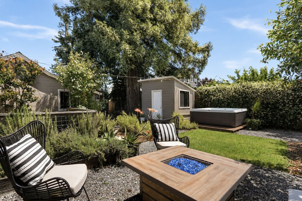 Private backyard retreat featuring a hot tub, fire pit, and multiple outdoor seating areas perfect for relaxing nights.