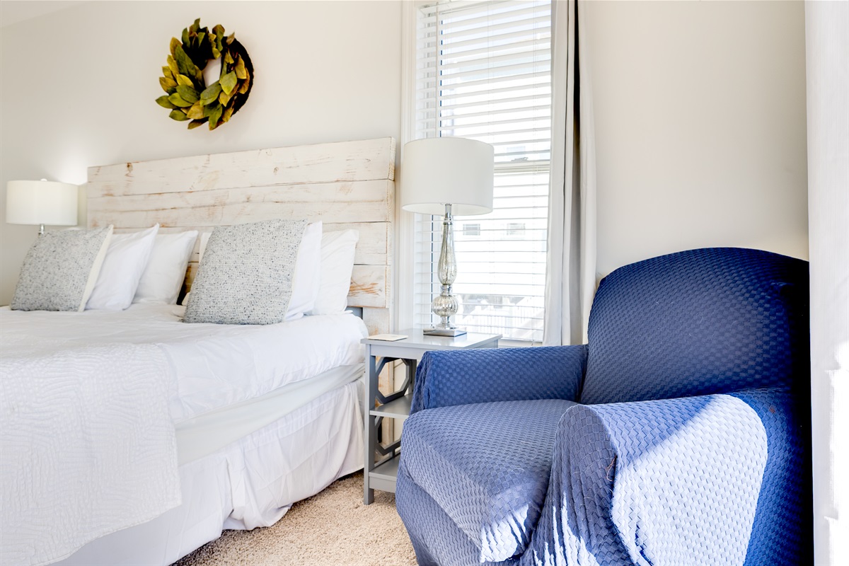 Relax in the serene master bedroom featuring a cozy reading chair