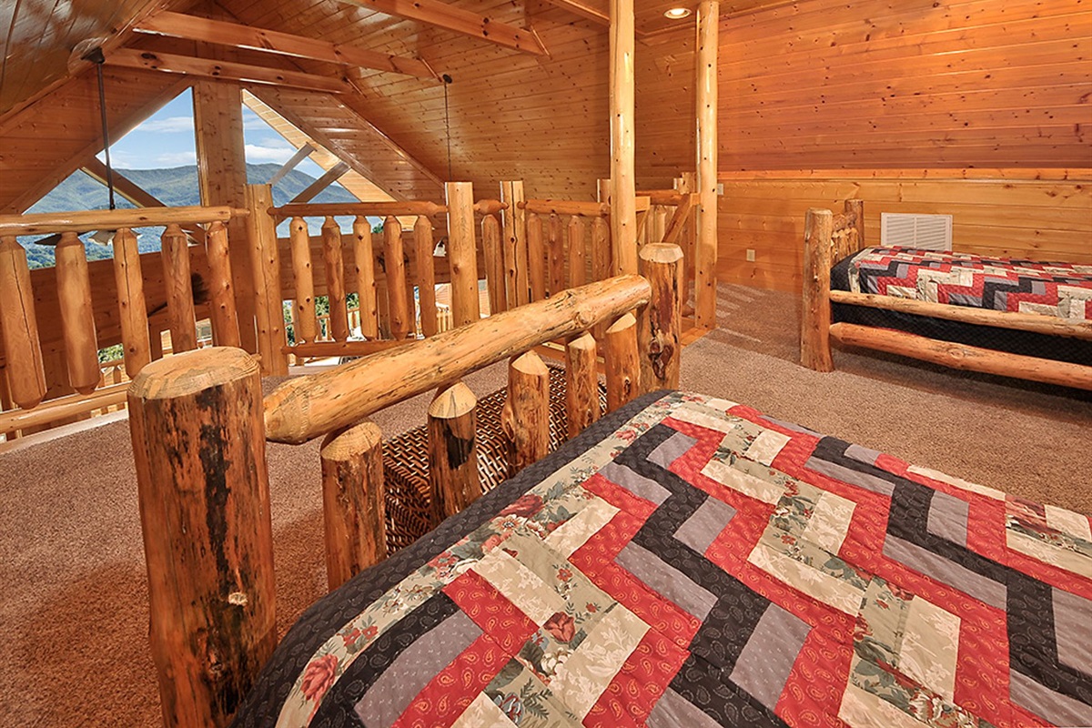 - Cozy loft bedroom featuring twin beds and warm log accents for family or friends   - Wake up to sunrise mountain views through stunning cabin windows   - A perfect space for kids or guests to enjoy the cabin&rsquo;s rustic charm