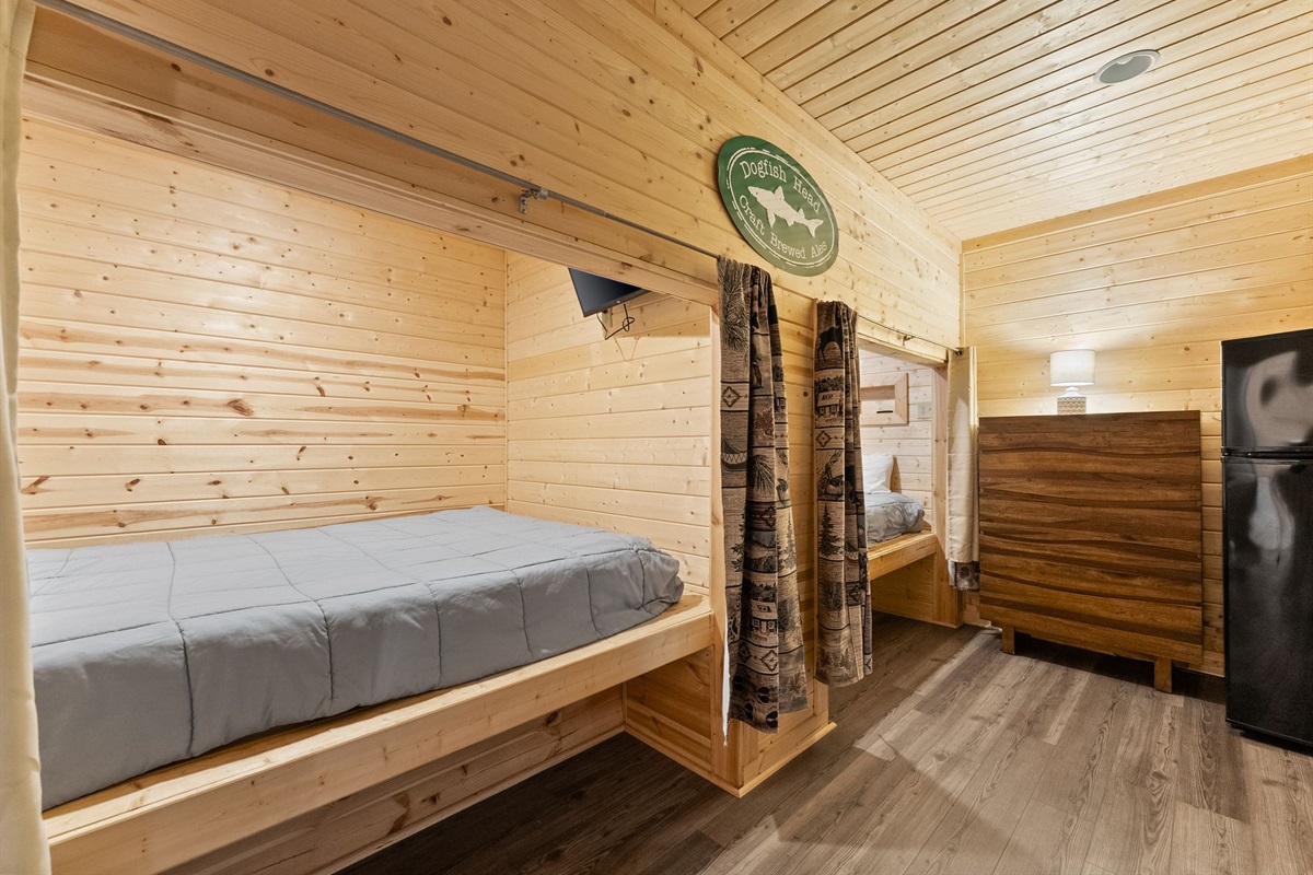 Lower-level open sleeping space featuring two cozy queen pods.