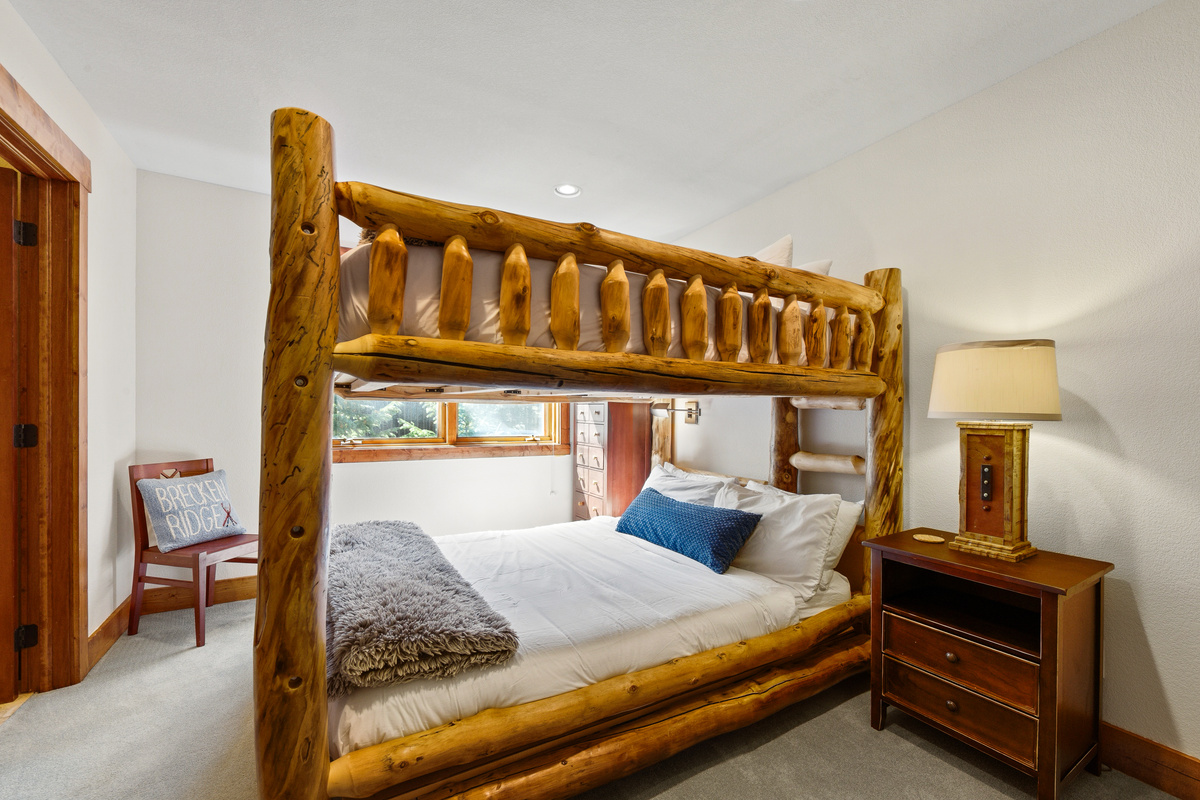 Upper level guest room with Queen-over-Queen bunk, tv, large window, and attached bathroom with shower. 