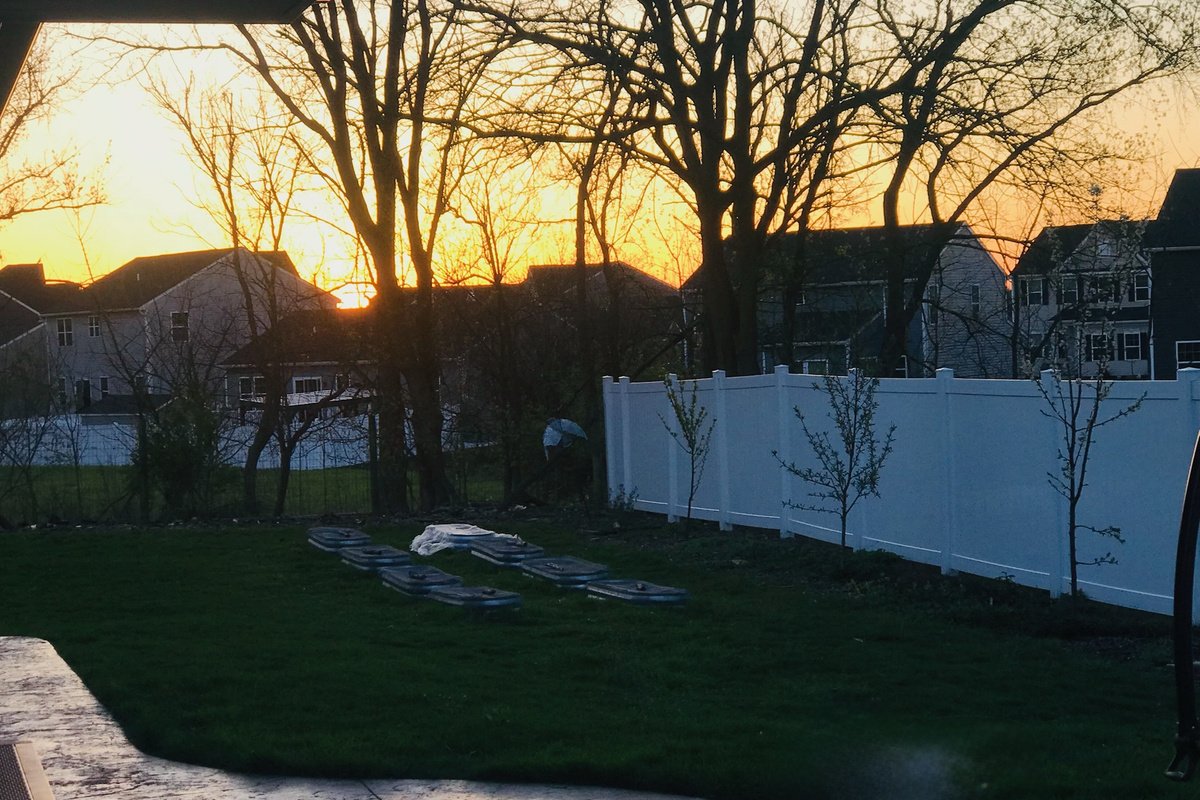 Peaceful sunset beyond the backyard fence.