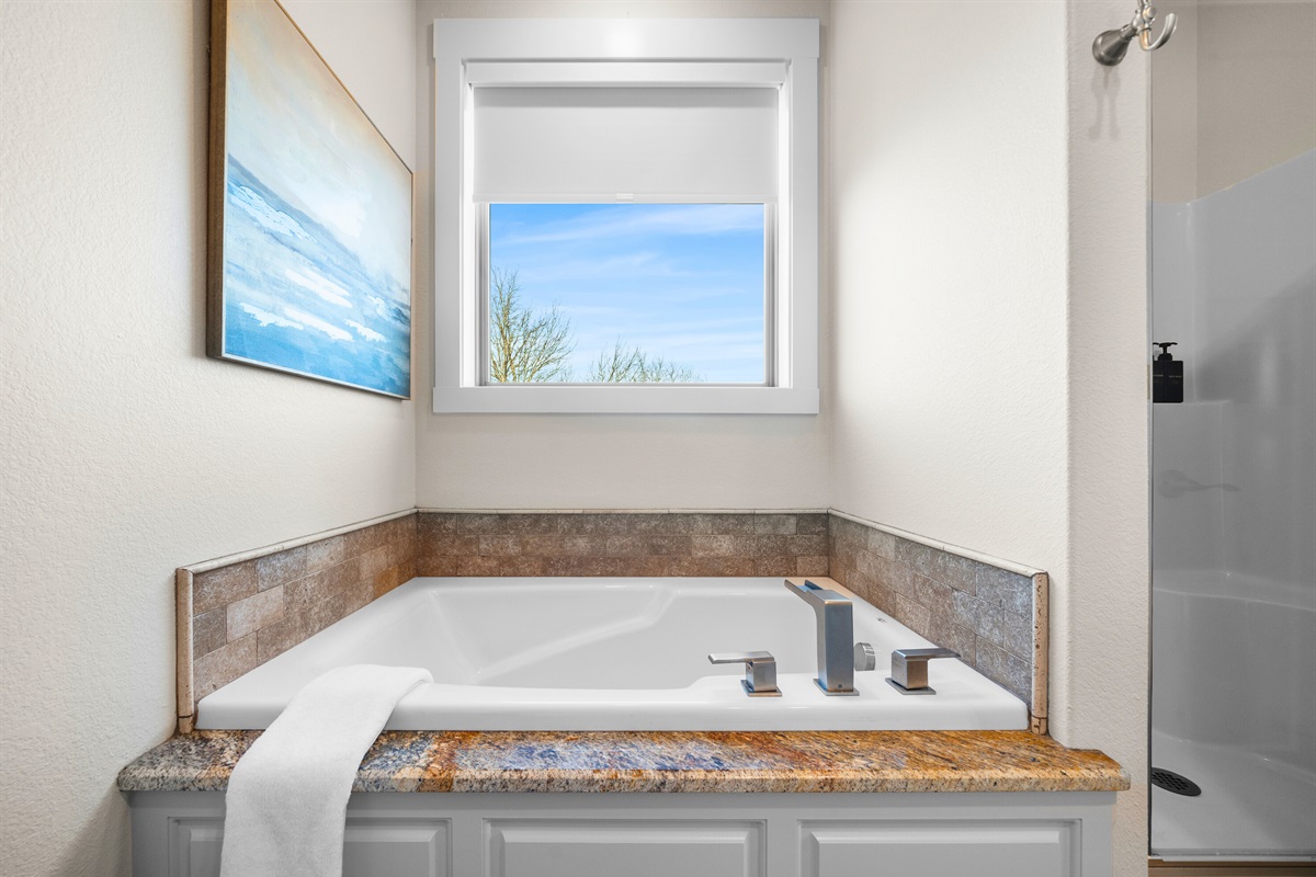 Soak in the deep tub beneath a picture window and let the peaceful scenery elevate your relaxation time.