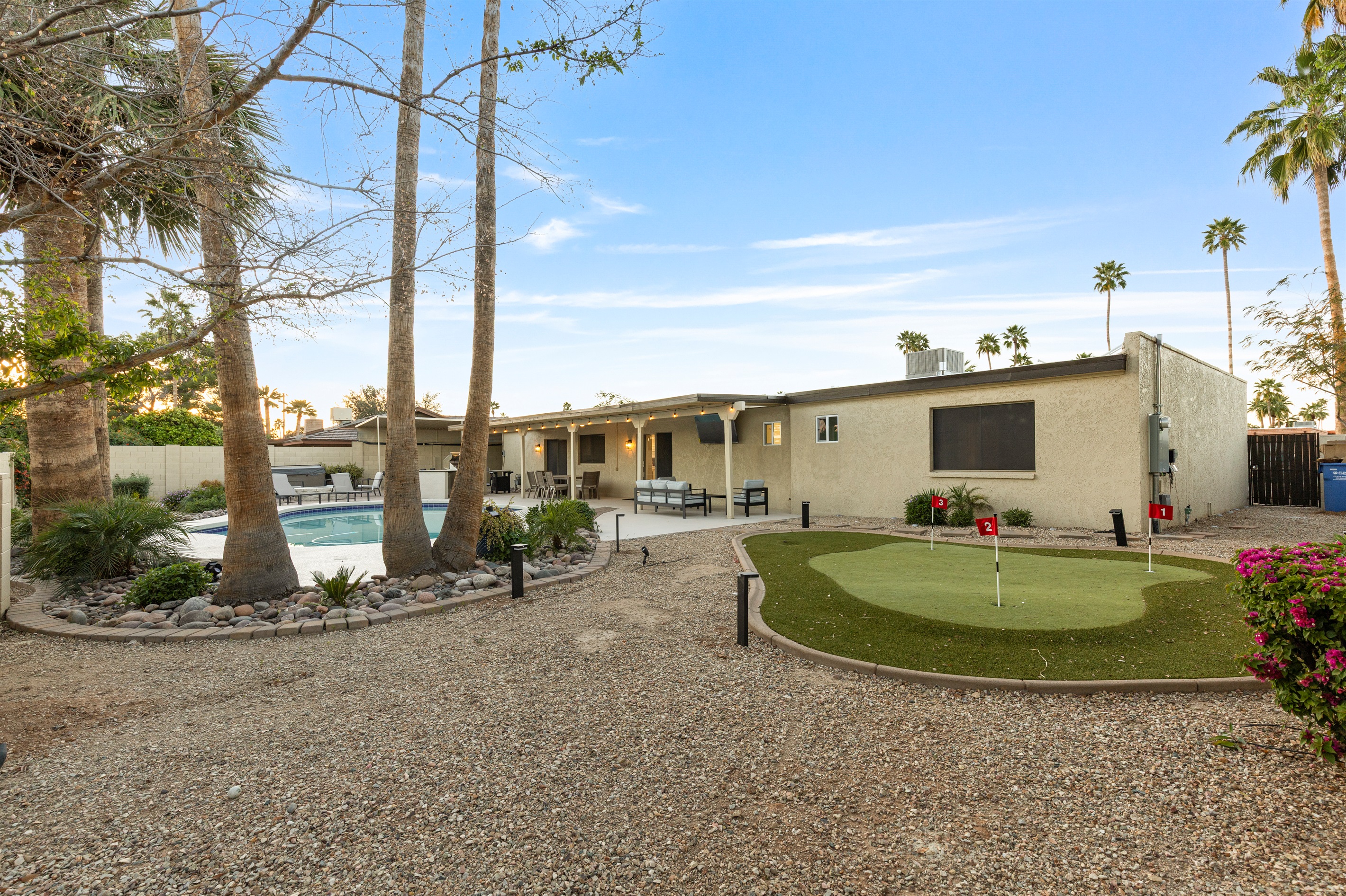 Spacious backyard with putting green and multiple areas to relax and unwind