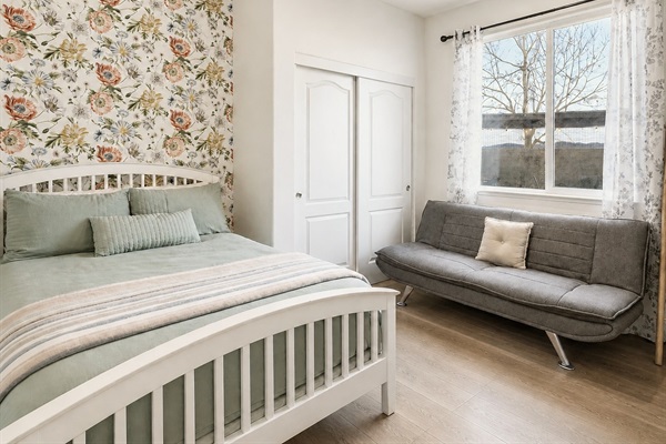 Cozy bedroom with floral accent wall on 1st floor