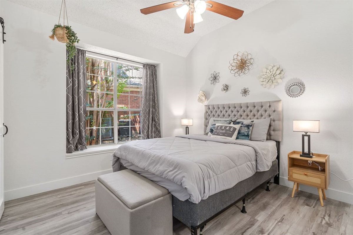 Bright and airy bedroom with queen bed, room darkening shades, and contemporary furnishings.