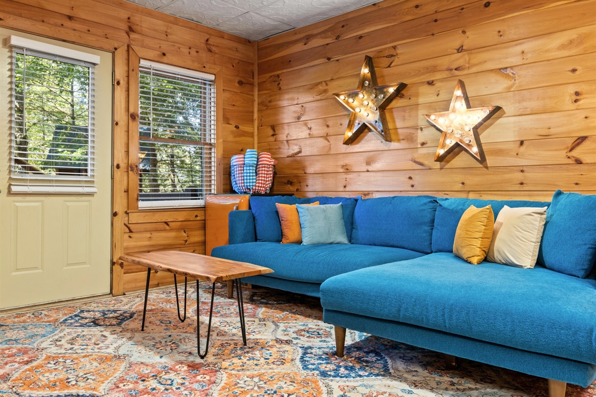 The game room calls, with a turquoise couch, mini fridge, and space to unwind.