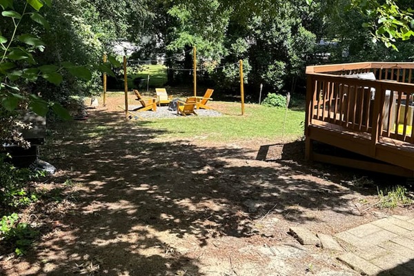 Spacious backyard with a gravel walkway provides open play areas and relaxing green space. 