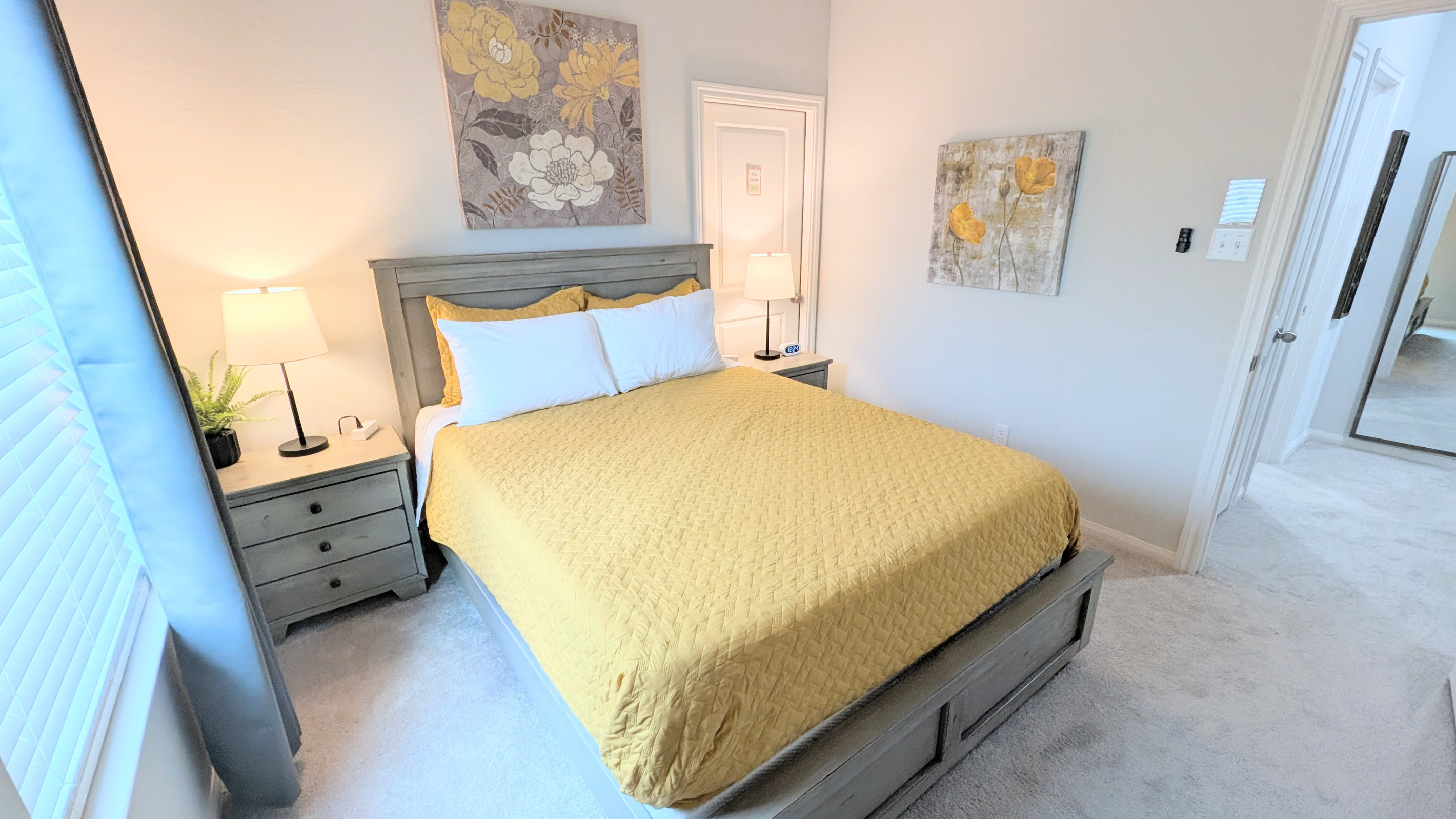 Bed has plush pillows and linens while bedside tables have easy access charging ports. 