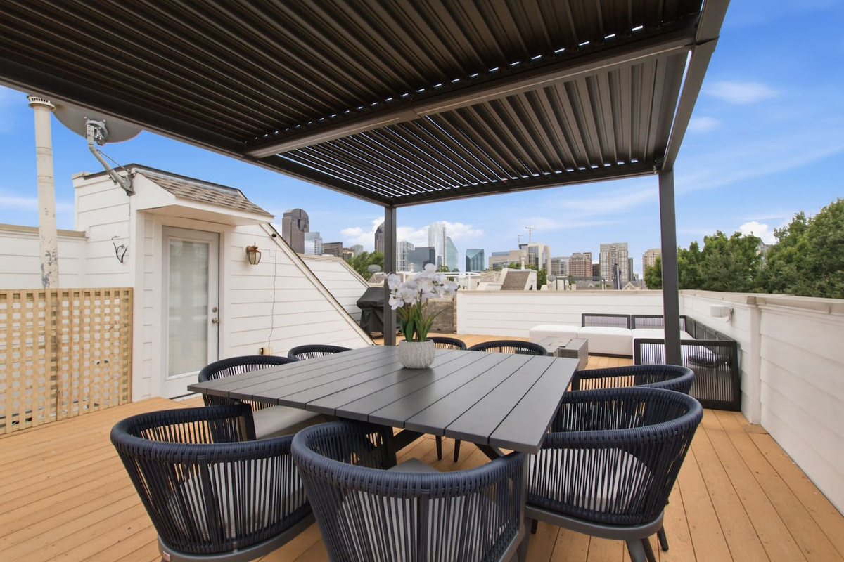 Rooftop outdoor dining table with open-sky views and the Dallas skyline in the background. Private, elevated, and genuinely hard to beat as an evening spot in this part of the city.