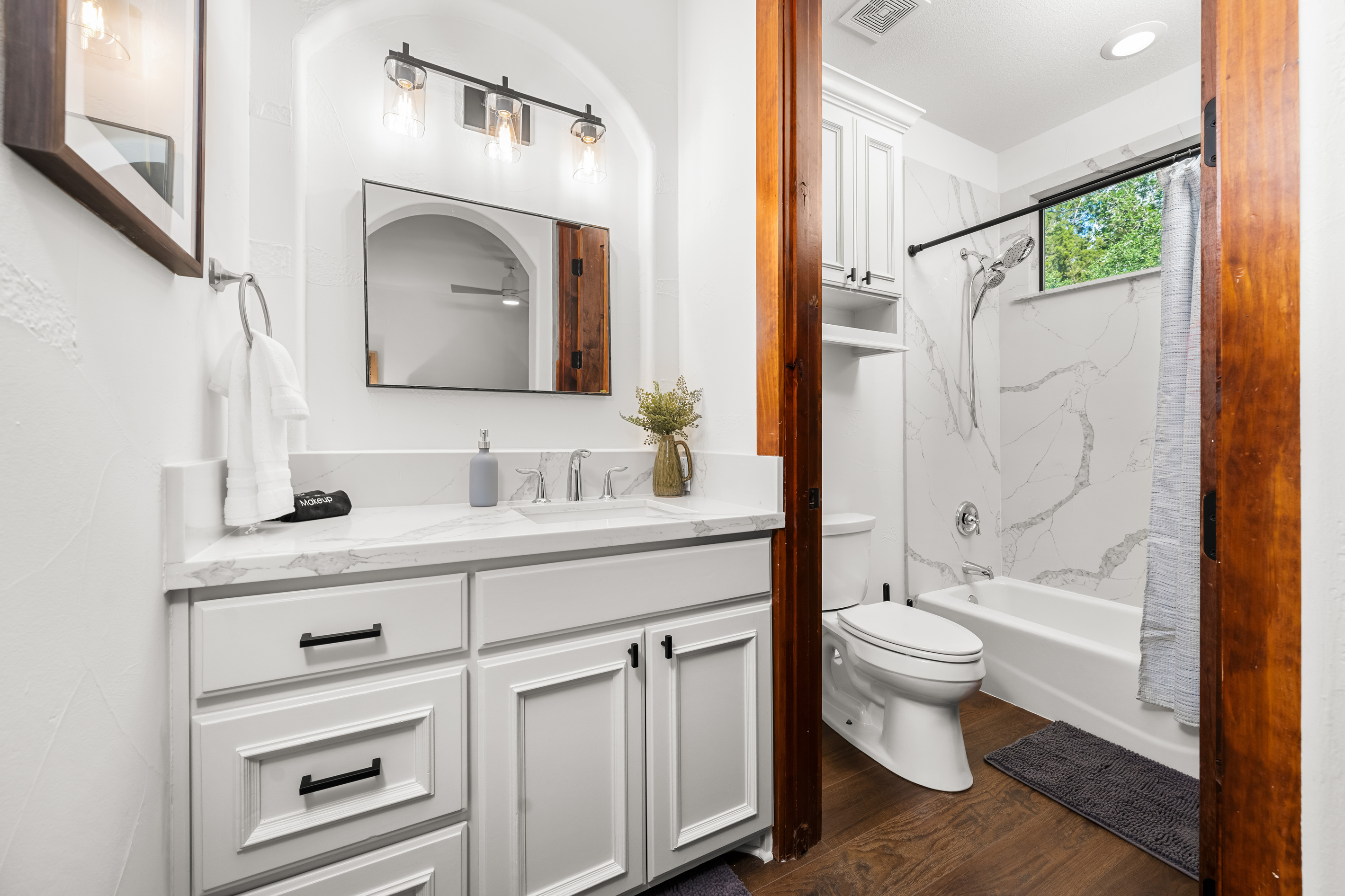A bright, inviting bathroom with a sink and combination tub and shower.