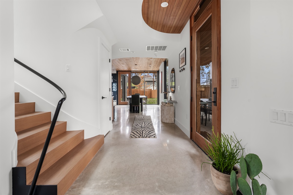 Step into a bright, modern entryway with soaring ceilings and clean architectural lines—an inviting first impression that sets the tone for your stylish Austin getaway.