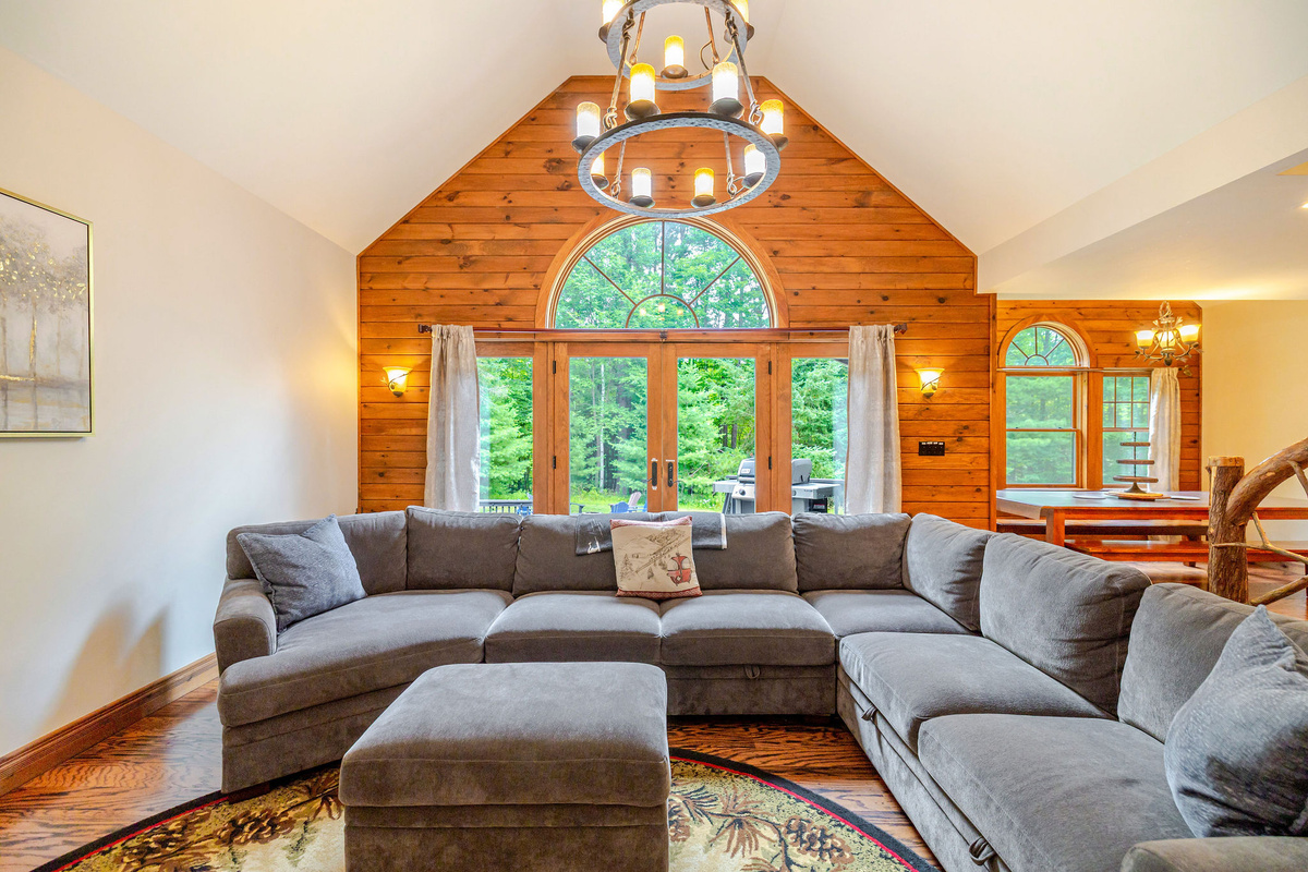 Gather in the soaring great room, where vaulted ceilings, rustic wood accents, and oversized windows create a warm and inviting space to relax after a day of Adirondack adventures.