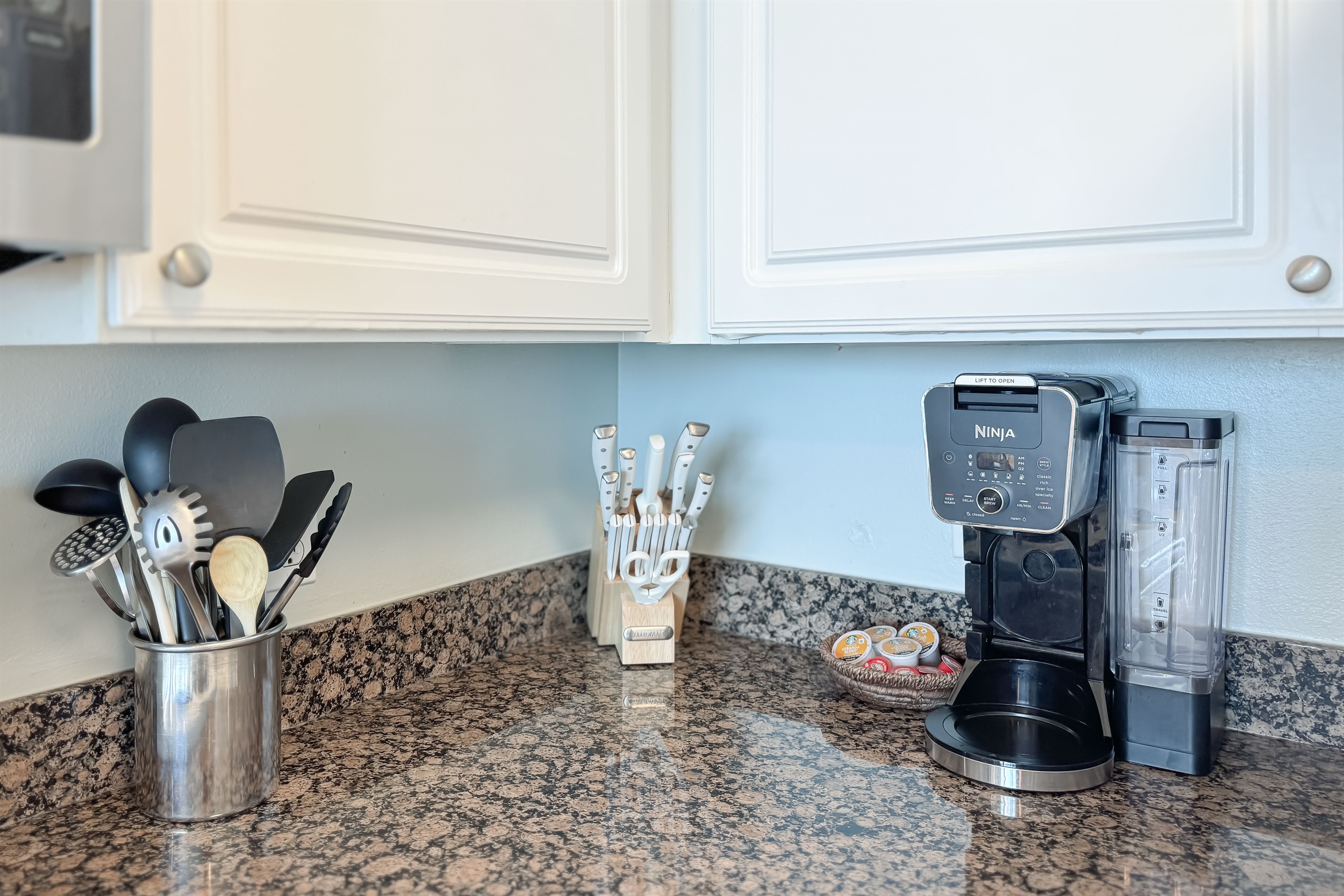 A tidy and functional kitchen countertop. This organized space, complete with coffee makers, a toaster, and a paper towel holder, makes everyday tasks a breeze.