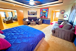 Spacious master's bedroom with a king bed, queen pull-out couch, cozy armchairs, and a Smart TV—perfect for relaxing in comfort