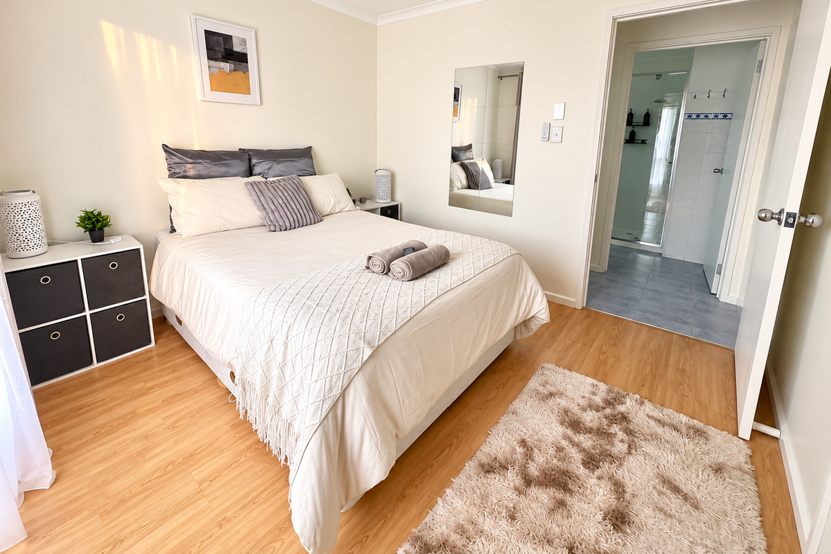 A relaxing bedroom at Carlenes Getaway with soft bedding, a ceiling fan and an adjoining bathroom just steps from the bed.