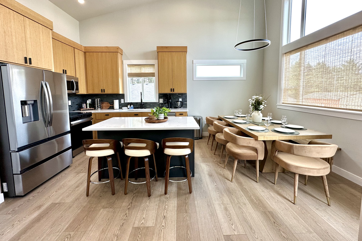 Kitchen and dining share the same open room — island seating for three plus a table that seats the whole group.