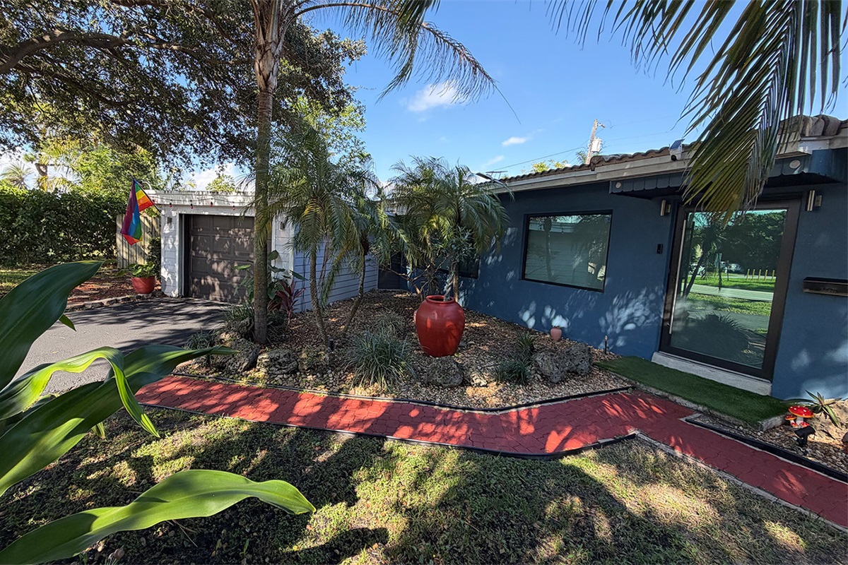 Garden of Manors exterior showcasing a quiet residential setting with lush greenery and shaded outdoor spaces.