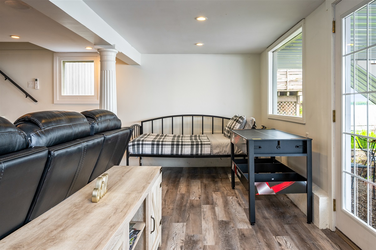 Enjoy lake views from this bonus seating area with a second daybed and game table—ideal for relaxing or playing indoors 🎲🌿