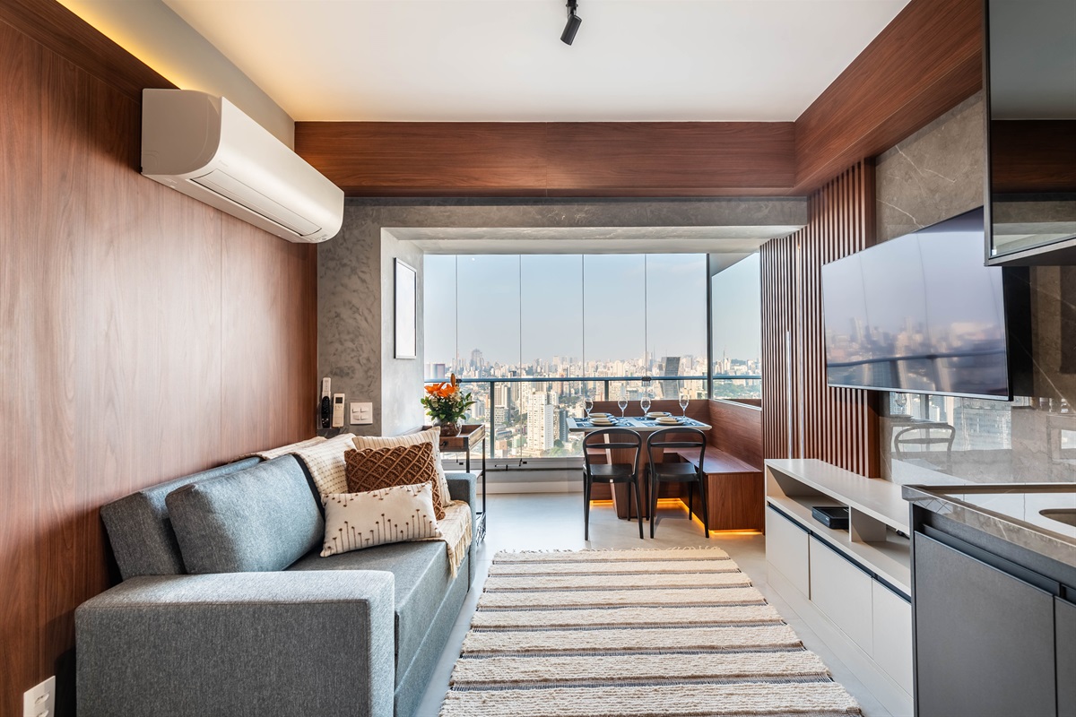 Conforto com TV e vista ✨ Sala com sofá confortável, TV e mesa de jantar integrada à varanda, ideal para lazer e relaxamento.