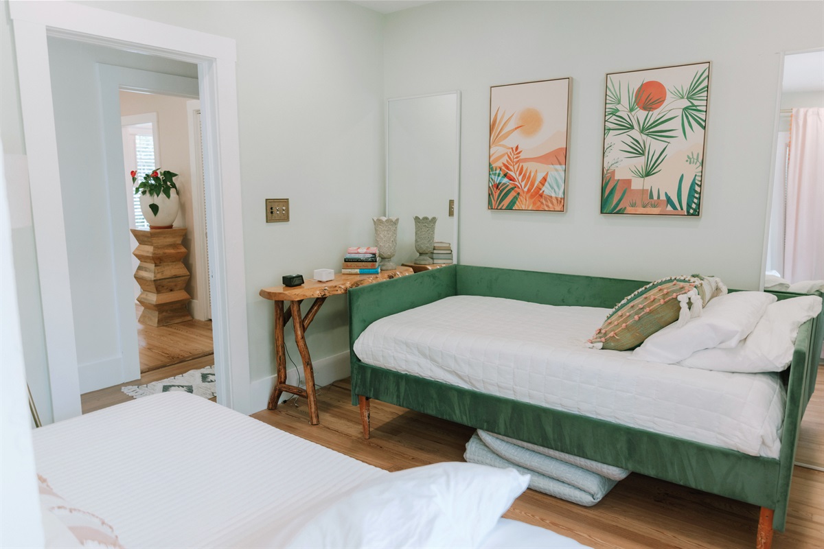 The third bedroom has a daybed and a pullout bed, garnished with colorful art throughout.
