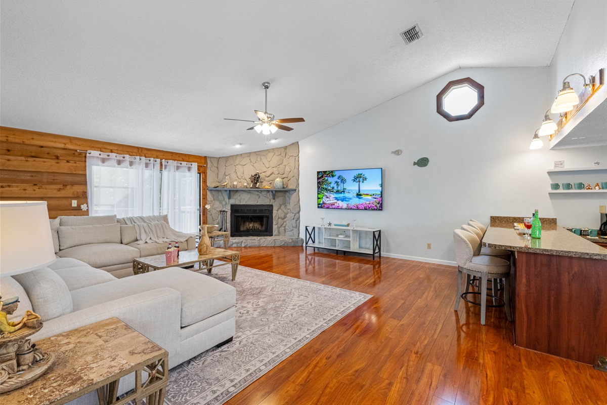 With rich hardwood floors, soaring ceilings, and a large, plush sectional, this is the kind of space that invites guests to kick off their shoes, sink in, and stay a while.