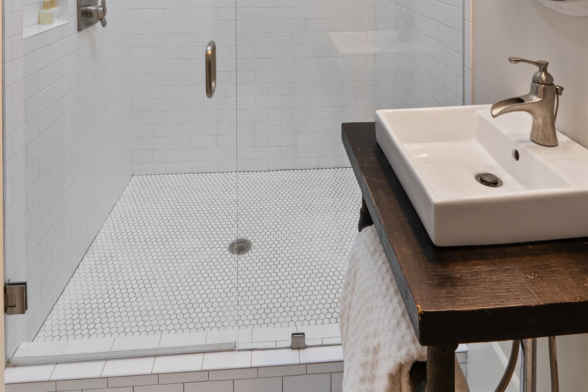The carriage house bathroom features a large walk-in shower, adding a touch of luxury and convenience for guests.