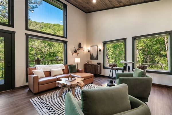 Open-concept living room with soaring ceilings and floor-to-ceiling windows.
