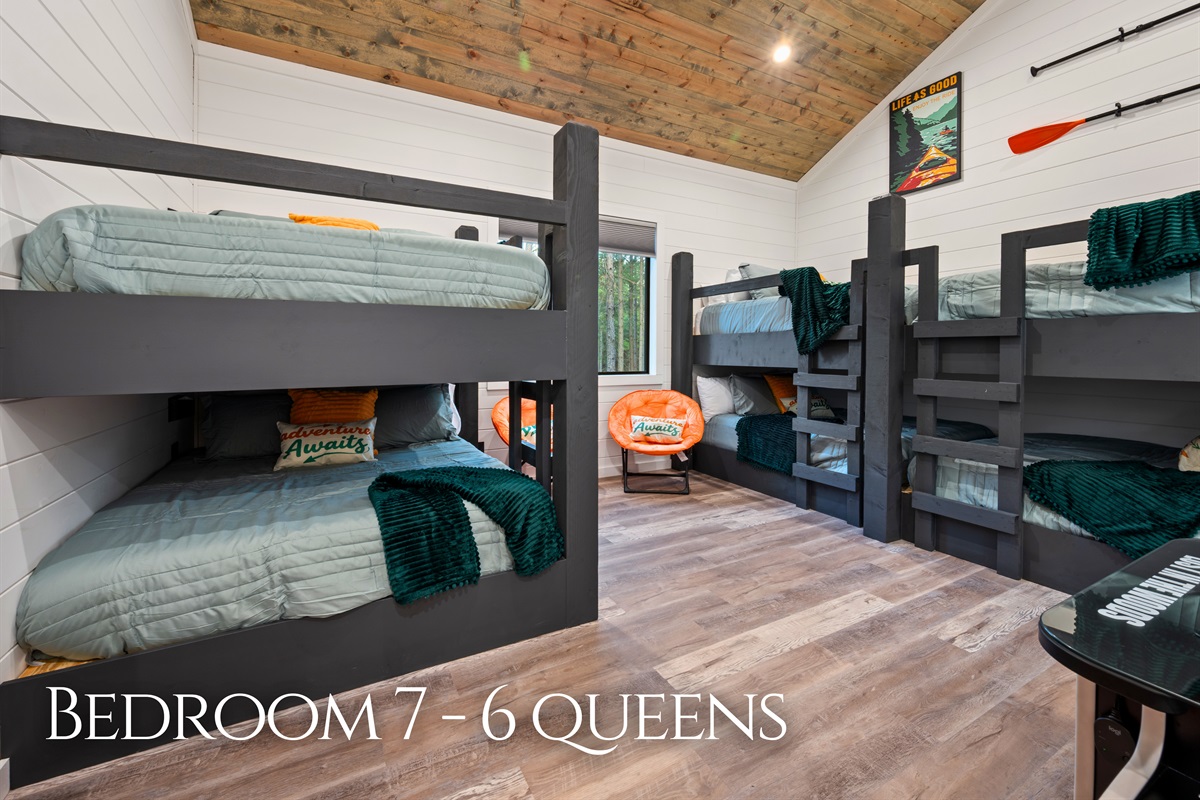 Designed for larger groups, this bunk room features six queen beds, giving everyone plenty of space to sleep comfortably.