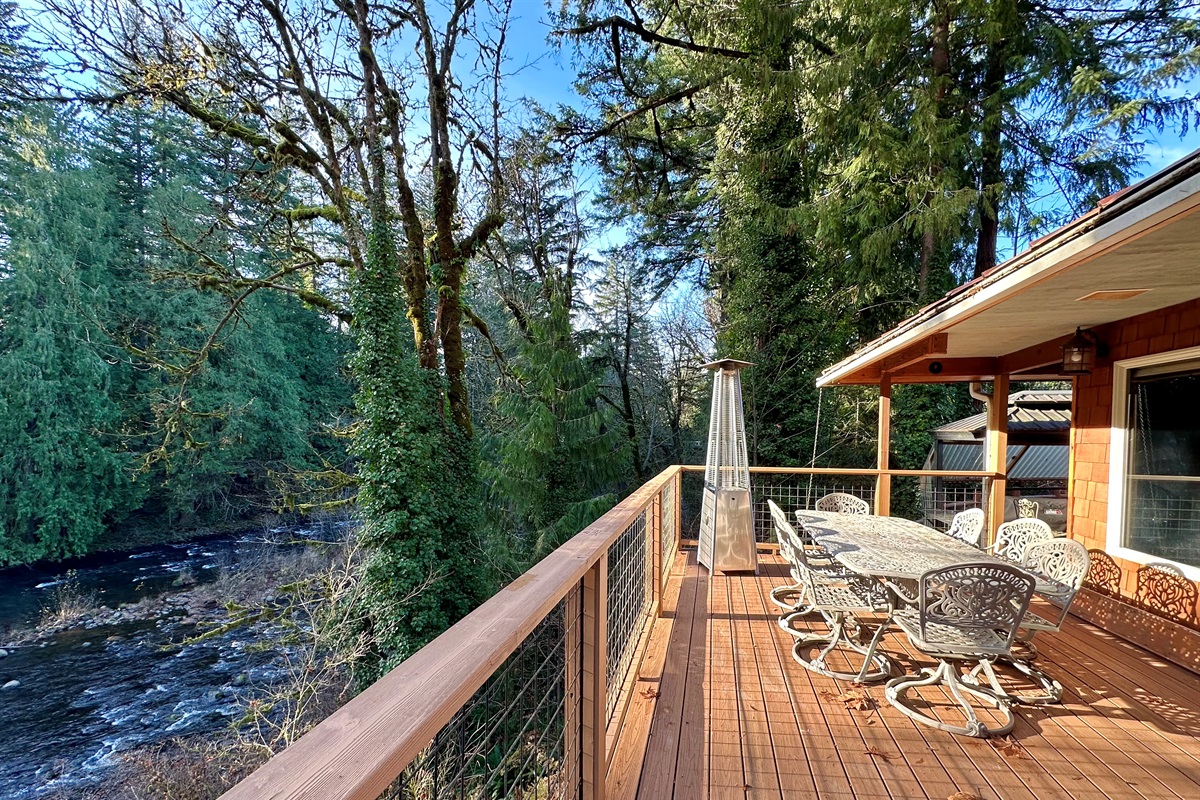 Soak up the sun and trees on 3 large decks overlooking the Salmon River from the main house. This deck is just off the living room and has plenty of room to eat outside on warm days.    