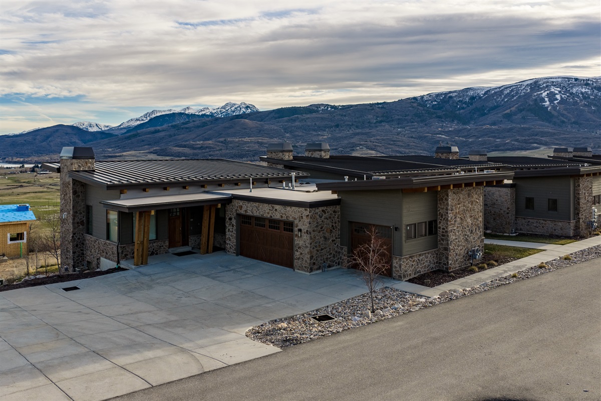 Modern mountain home exterior with stone accents and scenic surroundings