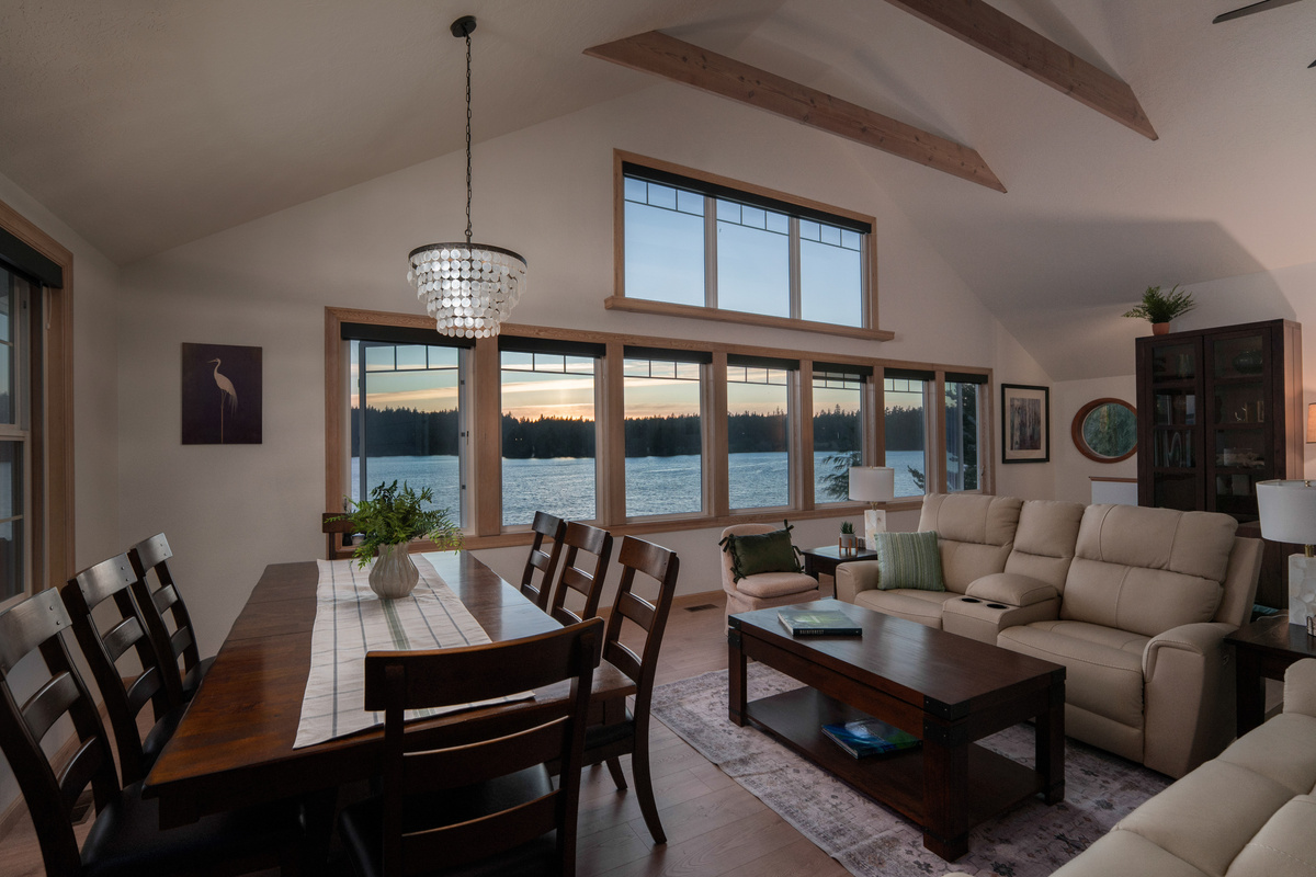 Golden-hour lake views fill the open living and dining space, creating a warm, peaceful setting for shared meals, relaxed conversations, and unforgettable evenings together.