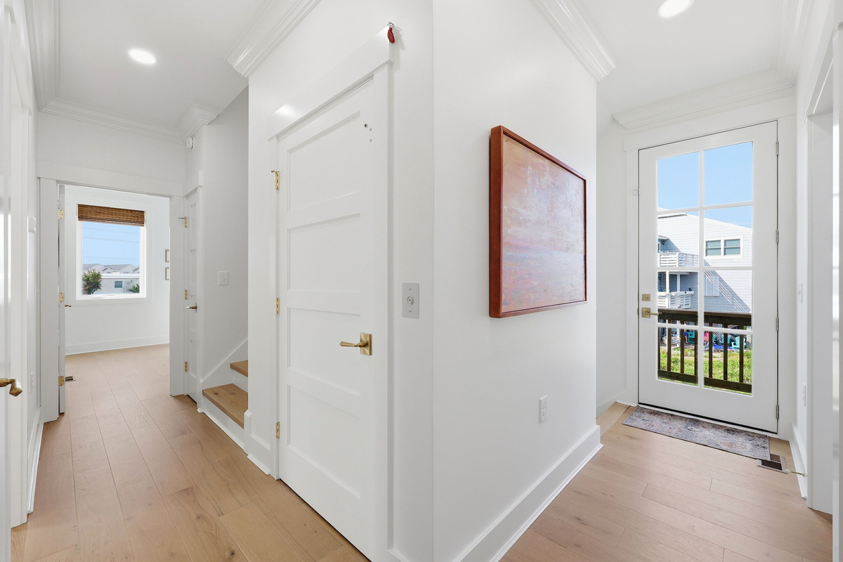 Entry hallway with staircase, natural light, and modern coastal finishes throughout