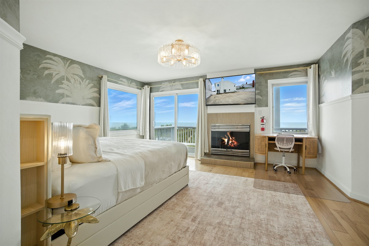 Primary Bedroom has ocean views, a King bed, a Large En-Suite Bathroom, a gas fireplace, desk and large walk-in closet