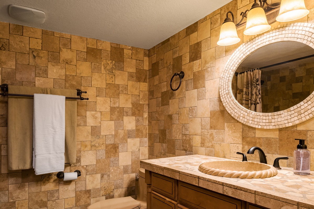 Soft lighting and earthy tilework create a warm, welcoming vibe for your morning routine or evening wind-down.