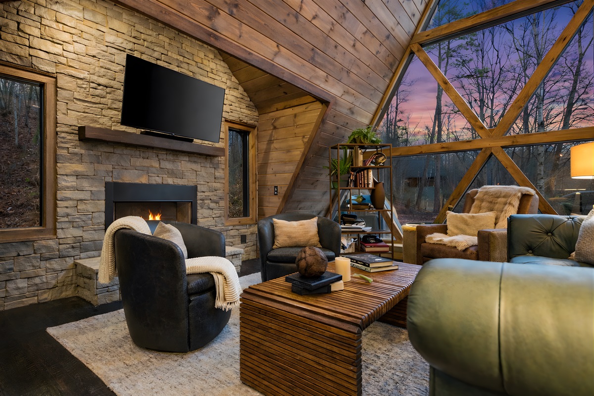Thoughtfully designed A-frame living with vaulted wood ceilings, a stone fireplace, and expansive glass bringing the outdoors in.