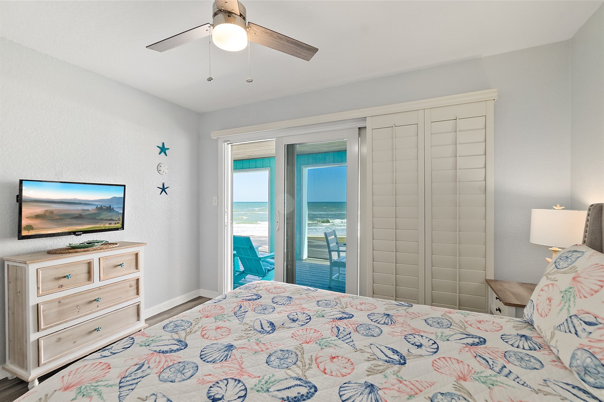 Primary bedroom with smart TV and sliding doors to patio