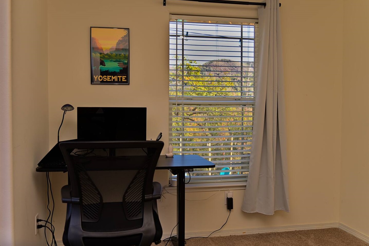 This office space, adorned with a sleek standing desk, invites focus and vitality against the backdrop of the majestic sierra mountain.