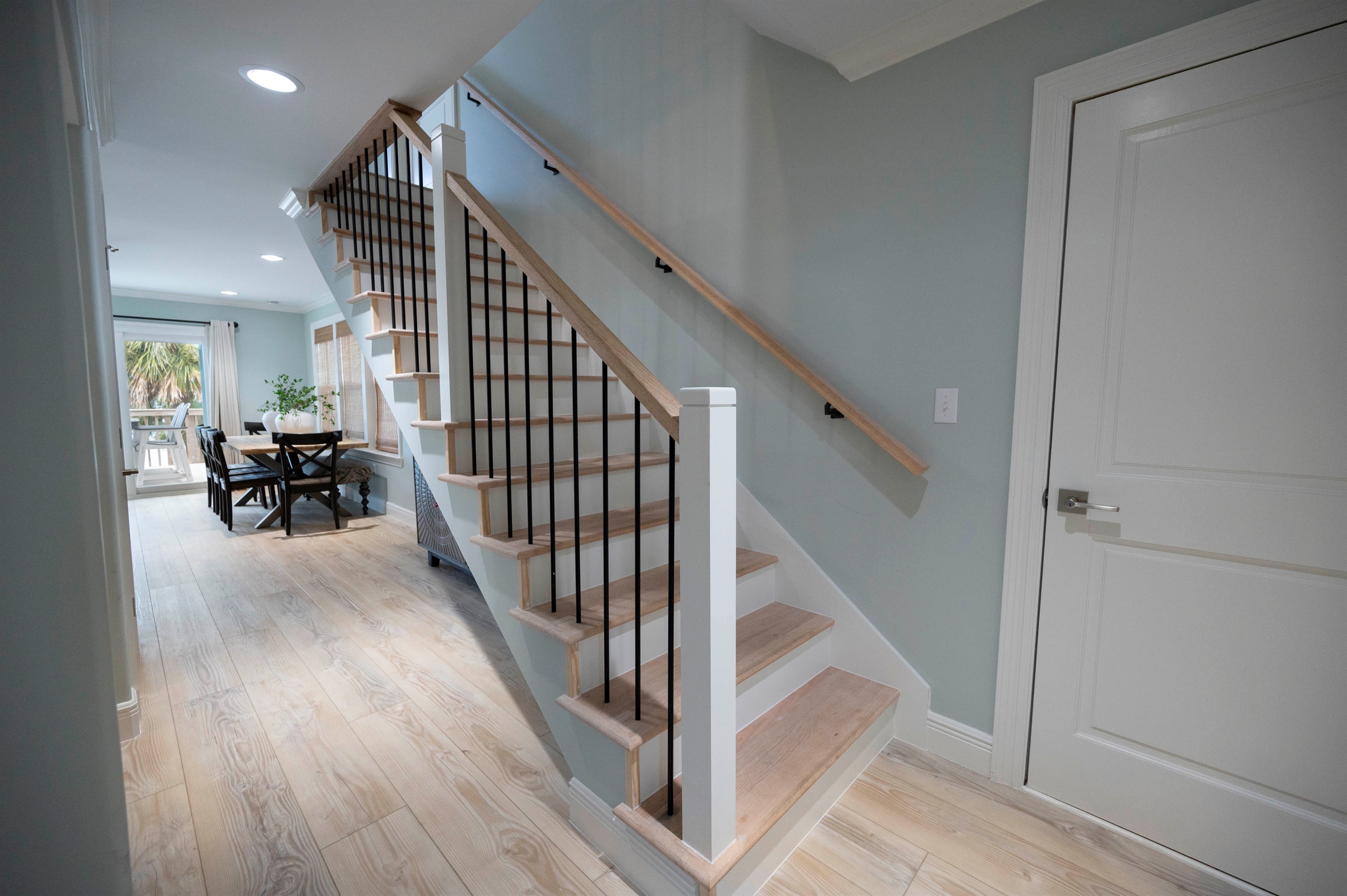 Bright and open modern home with a sleek staircase, stylish dining space, and natural lighting.
