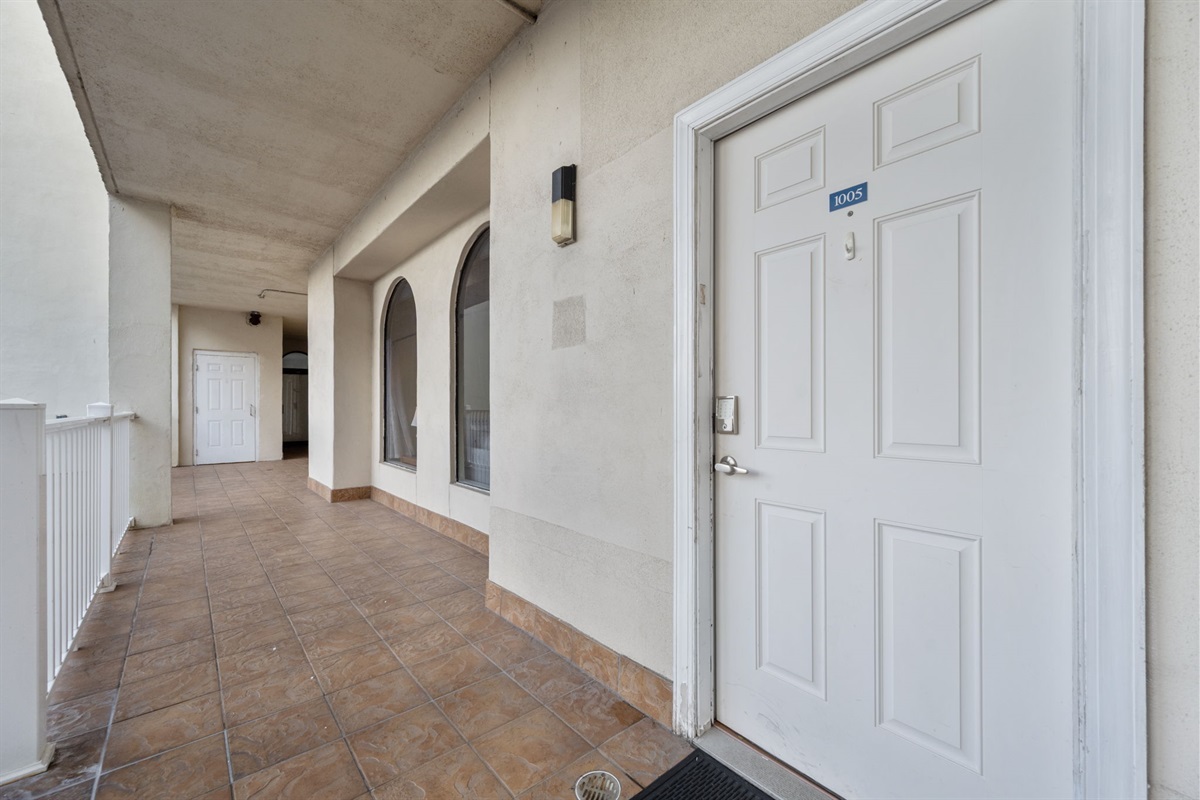 Unit entry along a covered walkway with elevator access nearby
