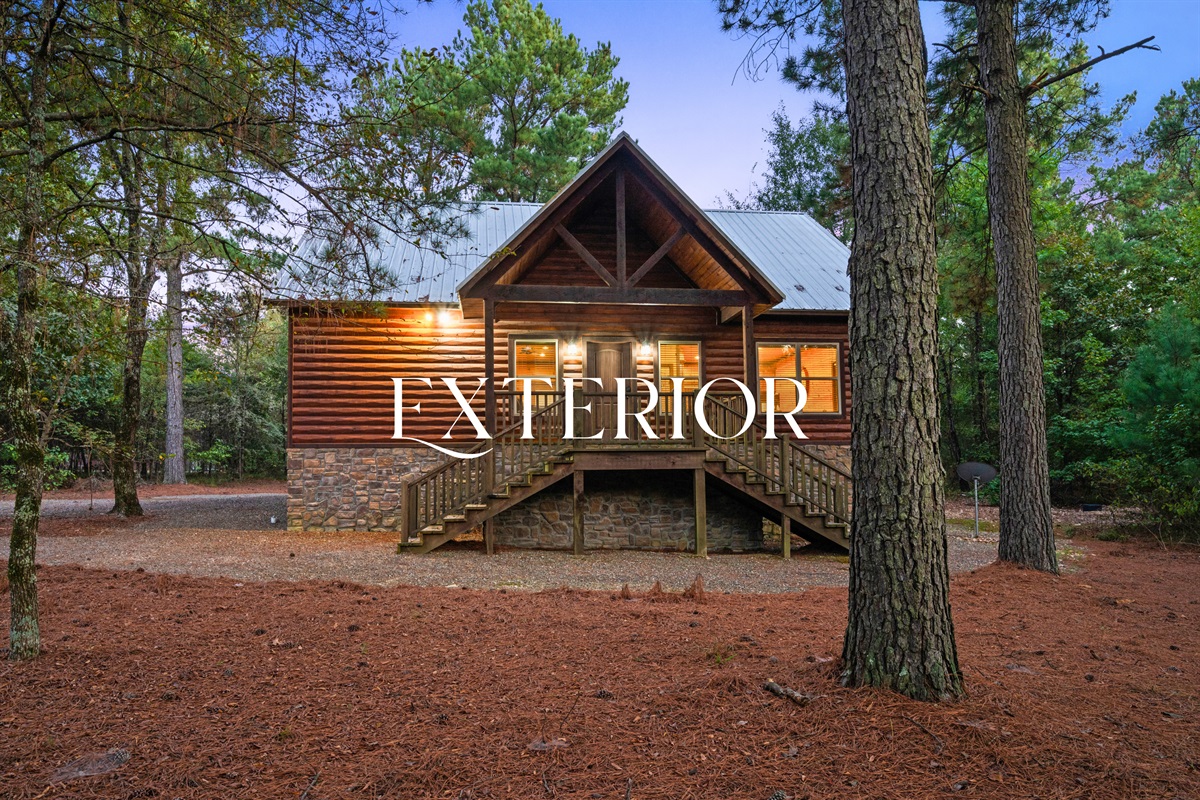 Exterior view of the cabin showing its charming wood design and setting.